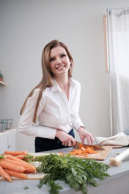 Diyetisyen mutfakta taze sebze kesti.