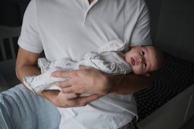 Babasıyla yeni doğmuş bir bebeğin ev portresi.