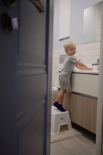 Kleiner blonder Junge lernt Zähneputzen in der Badewanne. — Stockfoto