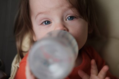 Plastik şişeden süt içen bir bebeğe yaklaş!
