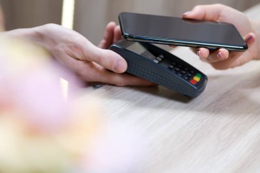 Kahve dükkanında el ve cep telefonu ödemesi, mobil ödeme konsepti