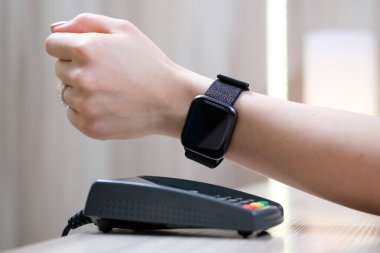 Kadınlar akıllı saatle NFC teknolojisiyle ödeme yapıyorlar.