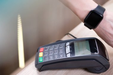 Adam akıllı saatle NFC teknolojisiyle ödeme yapıyor.