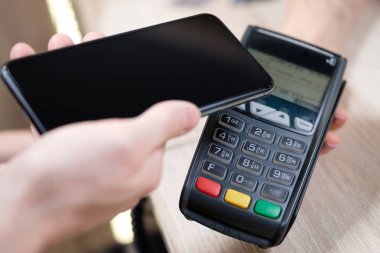 Kahve dükkanında el ve cep telefonu ödemesi, mobil ödeme konsepti