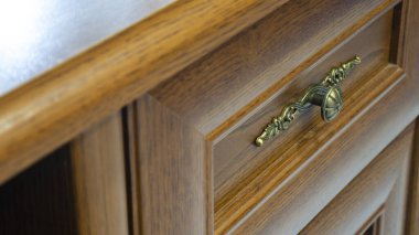 Bronz düğmeli koyu kahverengi çekmece. Macro çekimi, yakın plan.