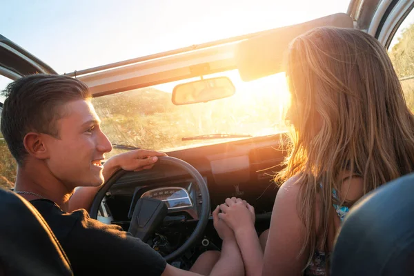 Pareja en un coche al atardecer — Foto de Stock