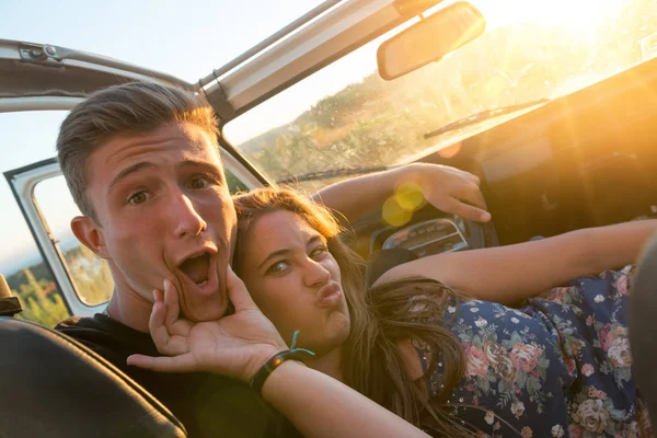 Koppel in een auto bij zonsondergang — Stockfoto