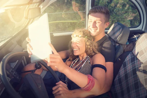 Casal em um carro ao pôr do sol — Fotografia de Stock