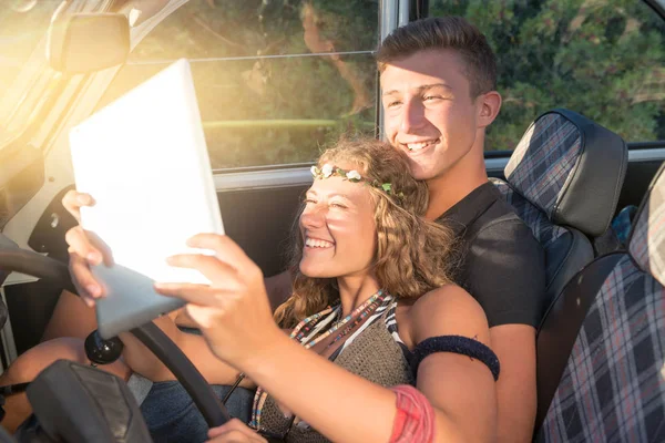 Couple in a car at sunset — Stock Photo, Image