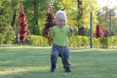 Bir çocuk parkta çim oynuyor.