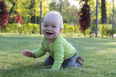 Bir çocuk parkta çim oynuyor.