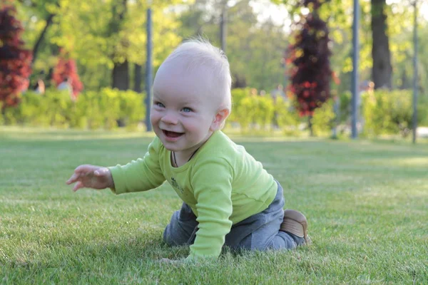 A gyermek játszik a parkban a fűben. — Stock Fotó