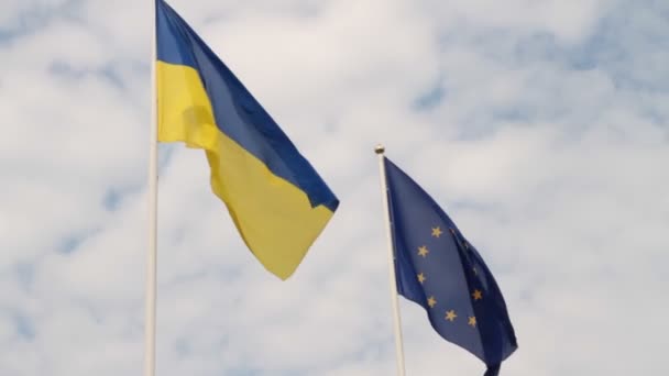 Bandiera dell'Ucraina e bandiera dell'Unione europea sventolano sullo sfondo di un cielo nuvoloso . — Video Stock