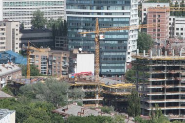 Mavi gökyüzüne karşı inşaat halindeki vinç ve bina