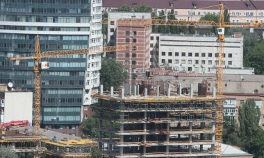 Mavi gökyüzüne karşı inşaat halindeki vinç ve bina