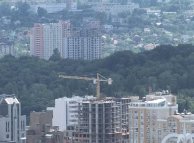 Mavi gökyüzüne karşı inşaat halindeki vinç ve bina