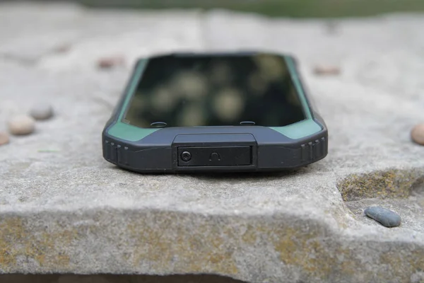 Telefone celular protegido em uma mesa de madeira . — Fotografia de Stock