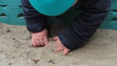 kum havuzunda oynayan çocuk