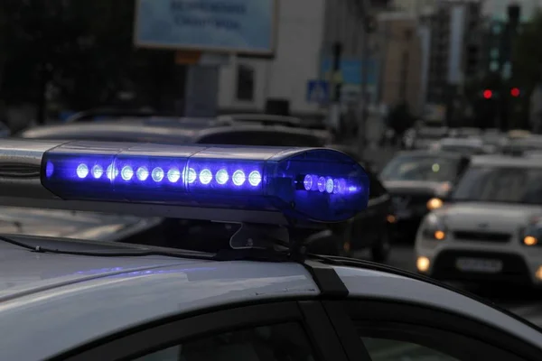 Coche de policía con luces encendidas. Luces de la ciudad al fondo. Con efecto vintage y difuminado . — Foto de Stock