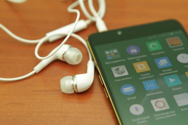 Tahta bir masanın üzerinde yatan siyah smartphone