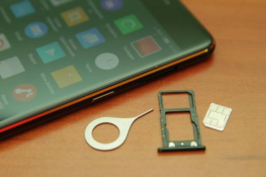 Tahta bir masanın üzerinde yatan siyah smartphone