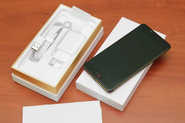 Tahta bir masanın üzerinde yatan siyah smartphone