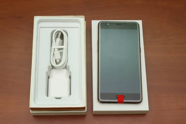 Tahta bir masanın üzerinde yatan siyah smartphone