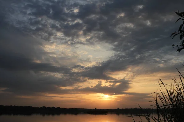 Vacker solnedgång grumlig blå ljusa himmel och gyllene ljus med siluett träd reflektera över lugna vatten i sjön — Stockfoto