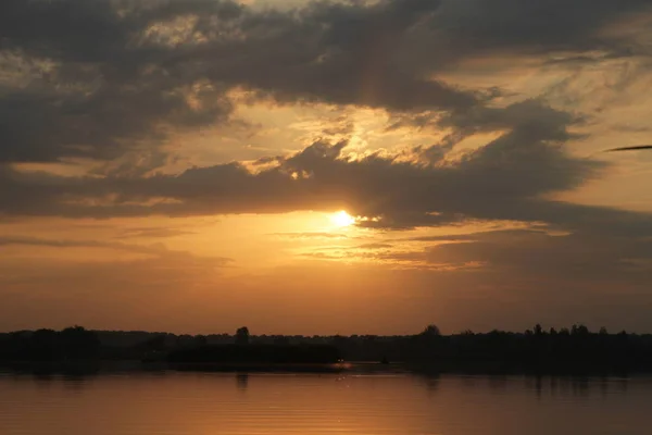 Vacker solnedgång grumlig blå ljusa himmel och gyllene ljus med siluett träd reflektera över lugna vatten i sjön — Stockfoto