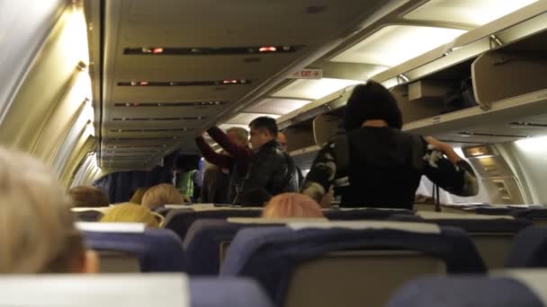 Passengers stack their luggage before the flight in the cabin of the plane. — Stock Video