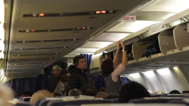 Les passagers empilent leurs bagages avant le vol dans la cabine de l'avion . — Video