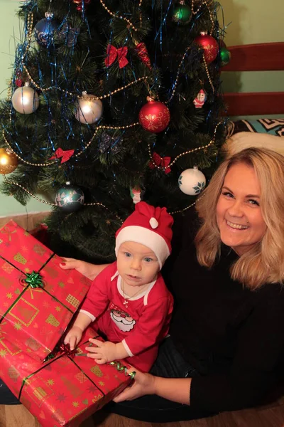 Feliz bebê pequeno bonito no traje do Papai Noel perto de decoração de árvore de Natal — Fotografia de Stock