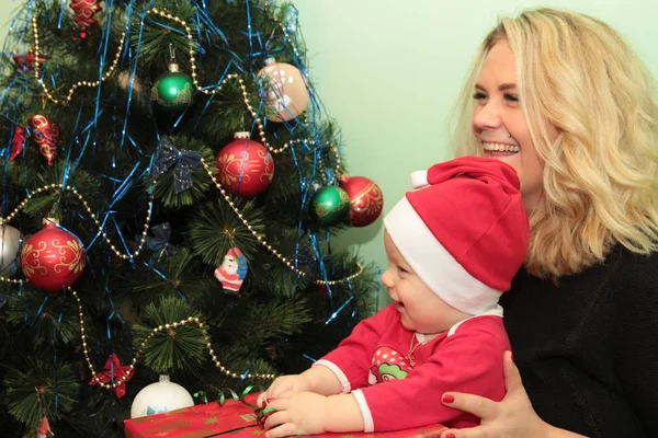 Gelukkig schattige kleine baby in Santa's kostuum in de buurt van Xmas tree decoreren — Stockfoto