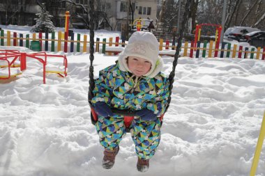 Kışın salıncak binen erkek bebek