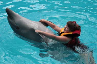 Mutlu çocuk ve Yunuslar mavi su. Yunus Terapisi destekli