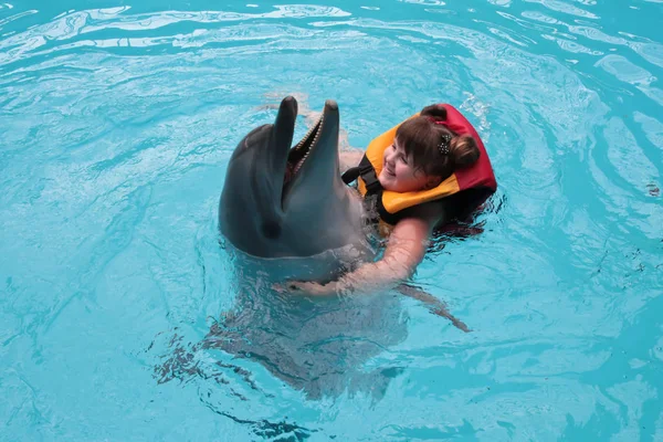 Niño feliz y delfines en agua azul. Terapia asistida con delfines — Foto de Stock