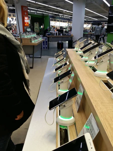 Kiev, 6 Mart 2018, Ukrayna. Alıcı bir akıllı telefon üstünde belgili tanımlık sayaç Kiev elektronik süpermarketlerde birini seçer