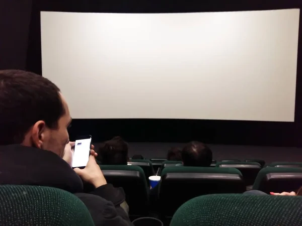 Cine pantalla blanca con asientos y personas siluetas — Foto de Stock