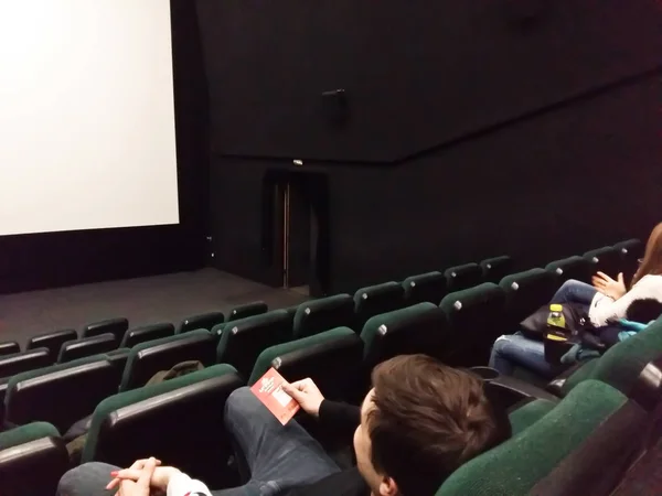 Cine pantalla blanca con asientos y personas siluetas — Foto de Stock