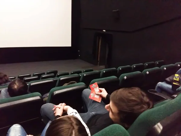 Cinema white screen with seats and people silhouettes — Stock Photo, Image