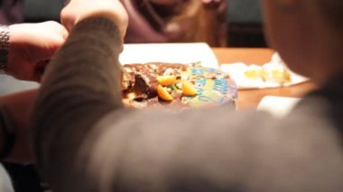 Bir kadın eli bir doğum günü pastası keser. Bir dilim pasta kesme. Kadın elinde yakın çekim