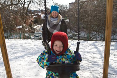 Çocuk kışın salıncak üzerinde