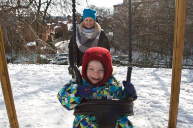 Çocuk kışın salıncak üzerinde