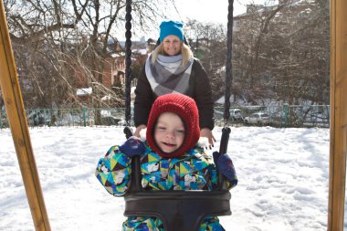 Çocuk kışın salıncak üzerinde