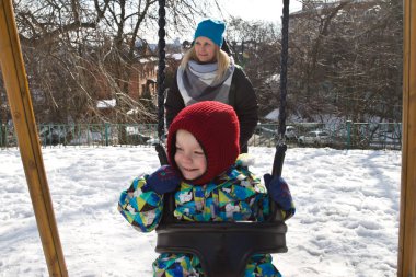 Çocuk kışın salıncak üzerinde