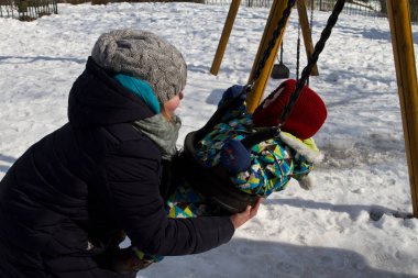 Çocuk kışın salıncak üzerinde