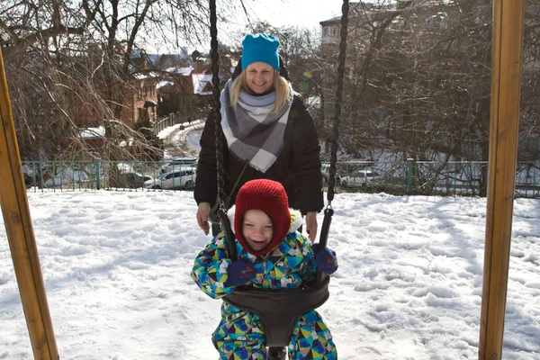 Çocuk kışın salıncak üzerinde