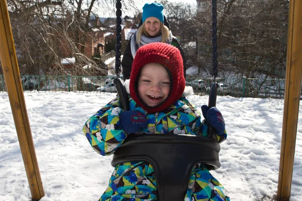 Çocuk kışın salıncak üzerinde