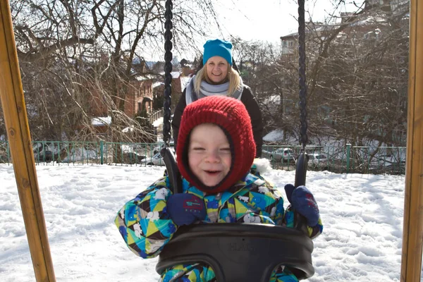 Çocuk kışın salıncak üzerinde