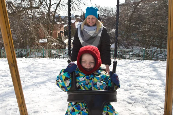 Çocuk kışın salıncak üzerinde